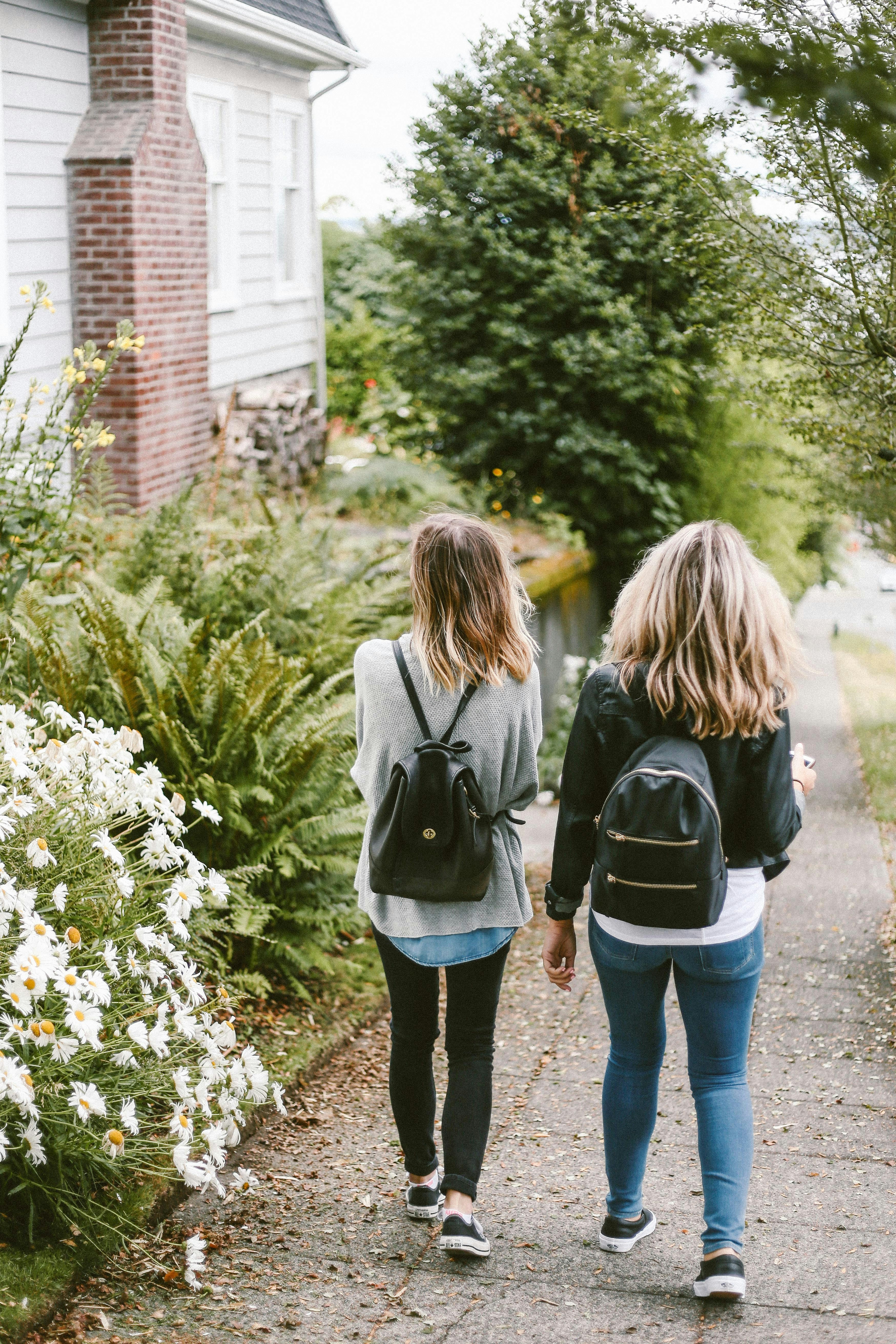 Two girls walking from school on a spring day